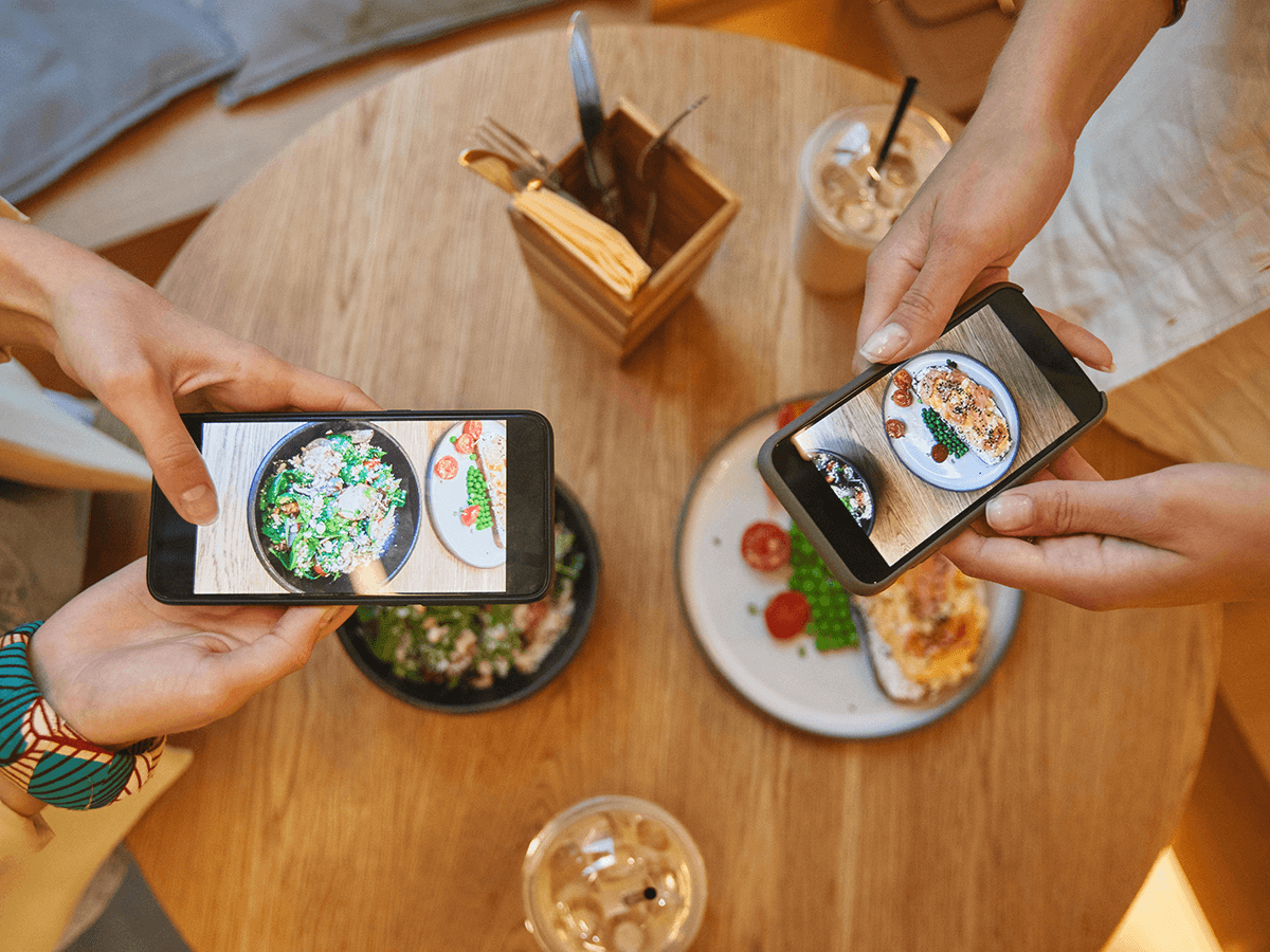 People are capturing food photos on their phones for social media content.