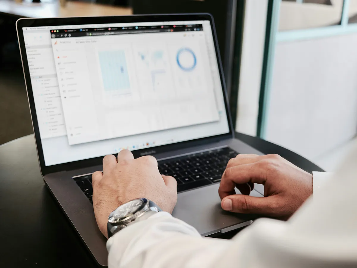Digital marketer analyzing website traffic on a laptop using a data dashboard.