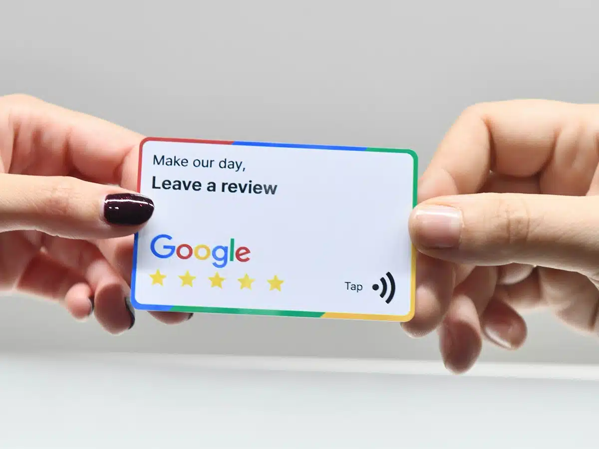 Hands offering a Google review card, encouraging customers to share their experience for better local search visibility.